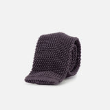 The Superknit Silk Tie by RALPH LAUREN PURPLE LABEL, crafted in Italy in a dark grey knit, is rolled up and showcased against a plain white background.