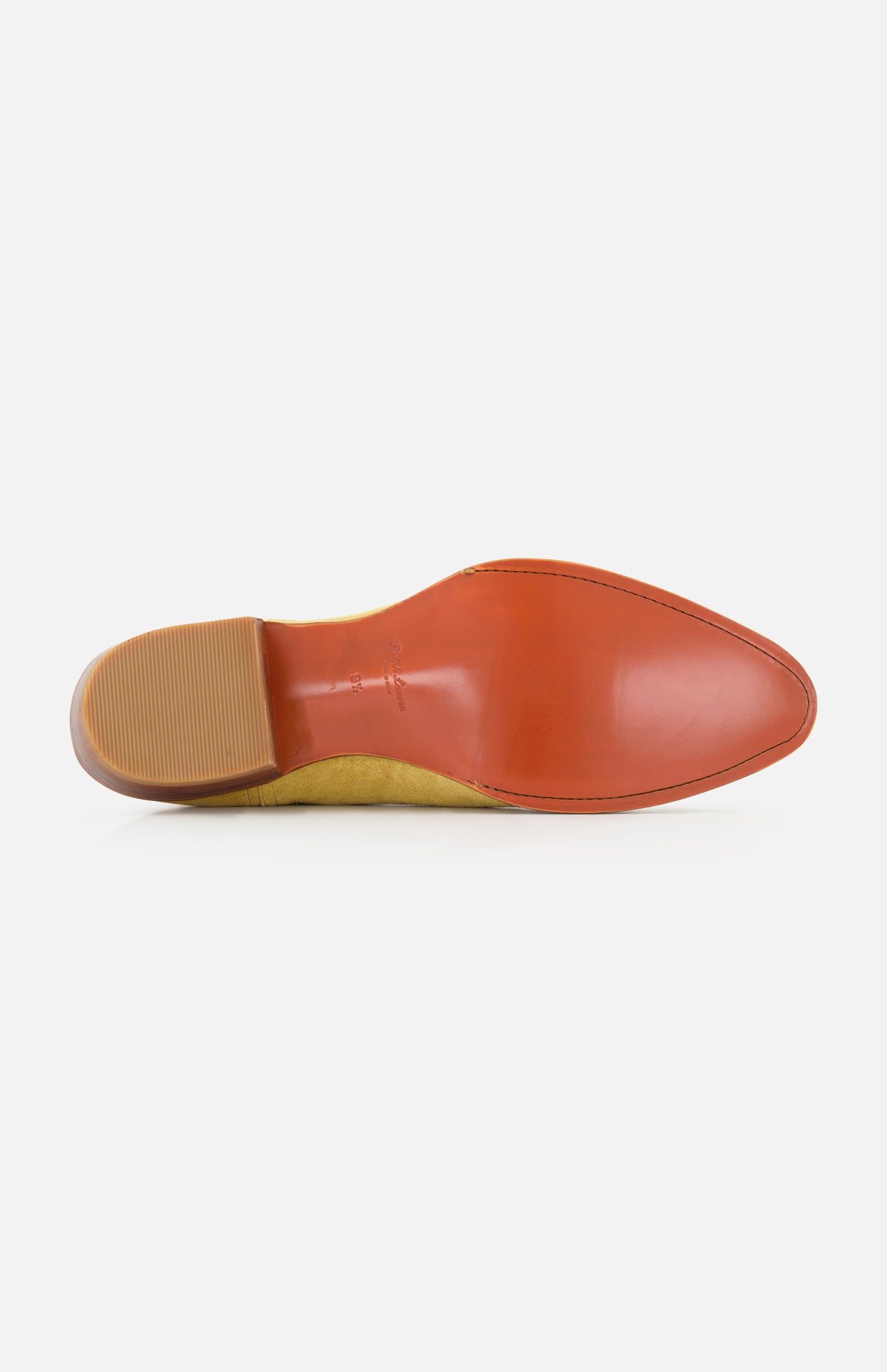 The image shows the bottom view of the RALPH LAUREN PURPLE LABEL Western Suede Mid Cut Boot, featuring a pointed silhouette with a smooth, shiny brown sole and a textured rubber heel—details that reflect the exceptional craftsmanship typical of high-quality tan boots.