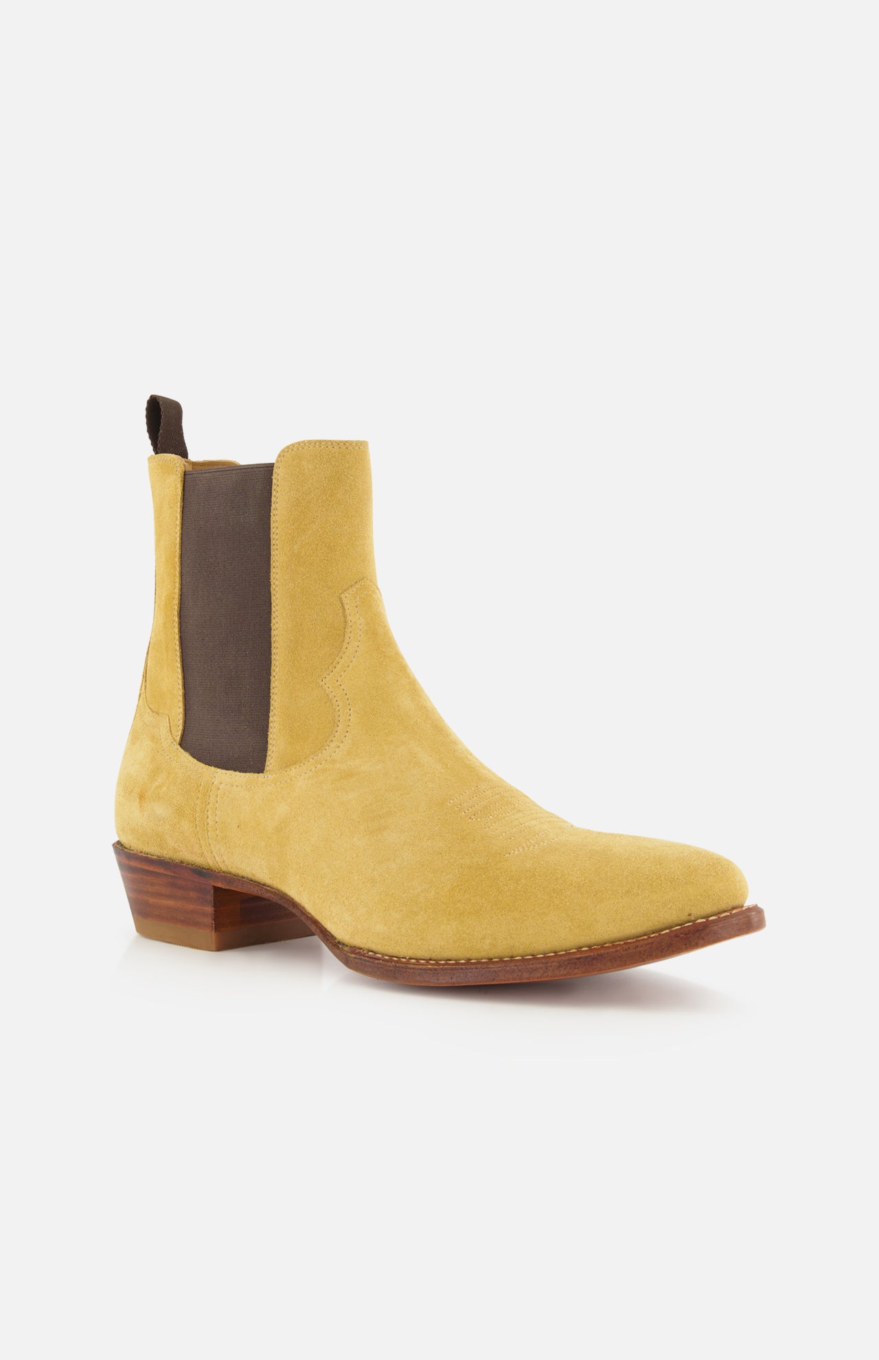 The Western Suede Mid Cut Boot by RALPH LAUREN PURPLE LABEL—a single yellow suede Chelsea boot featuring a brown elastic side panel, wooden heel, and pull tab—offers a modern interpretation of classic western style, shown against a white background.