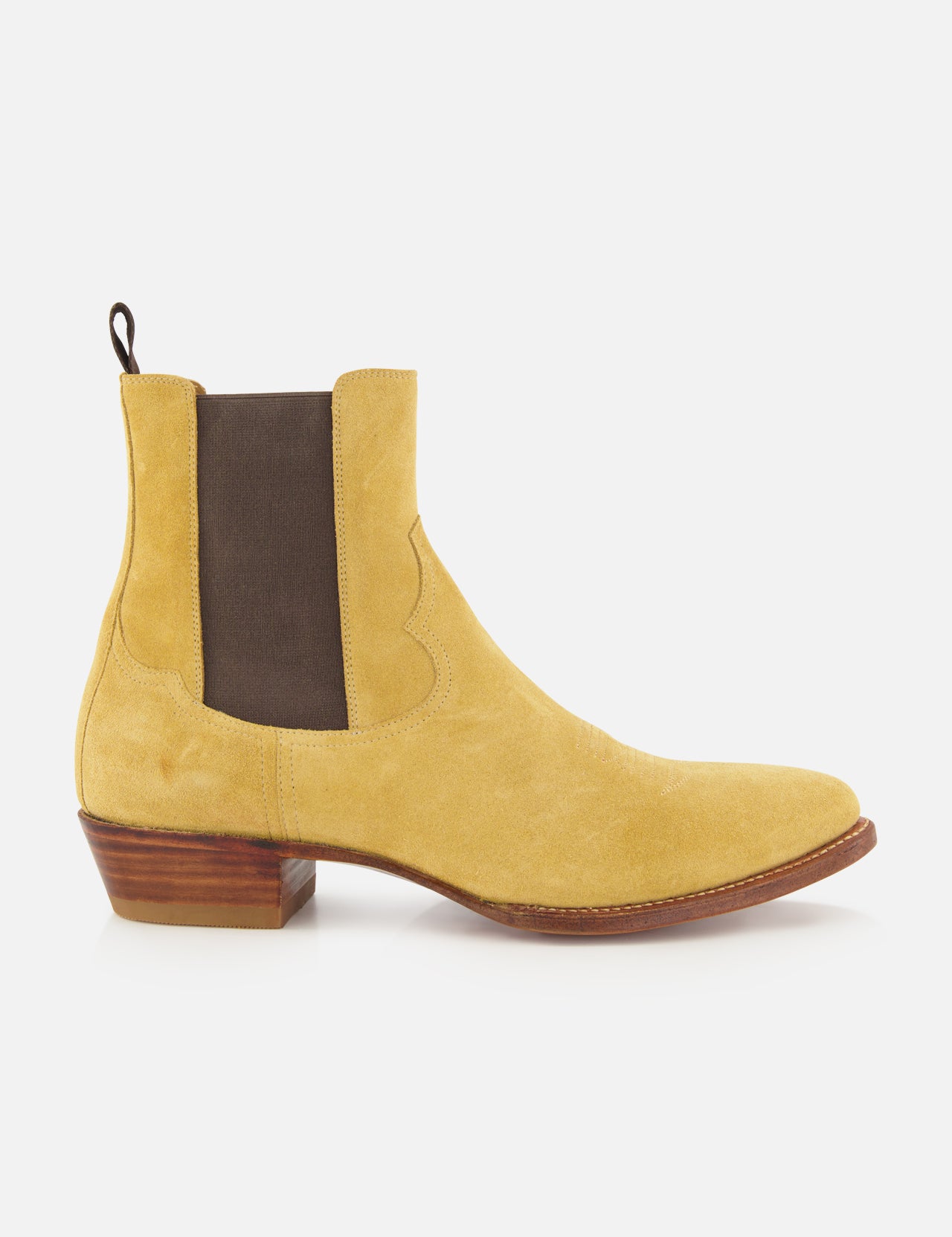 The RALPH LAUREN PURPLE LABEL Western Suede Mid Cut Boot, shown from the side on a white background, is a tan suede Chelsea-inspired design featuring classic western boot elements, including a brown elastic side panel, back pull tab, low stacked wooden heel, and brown sole.
