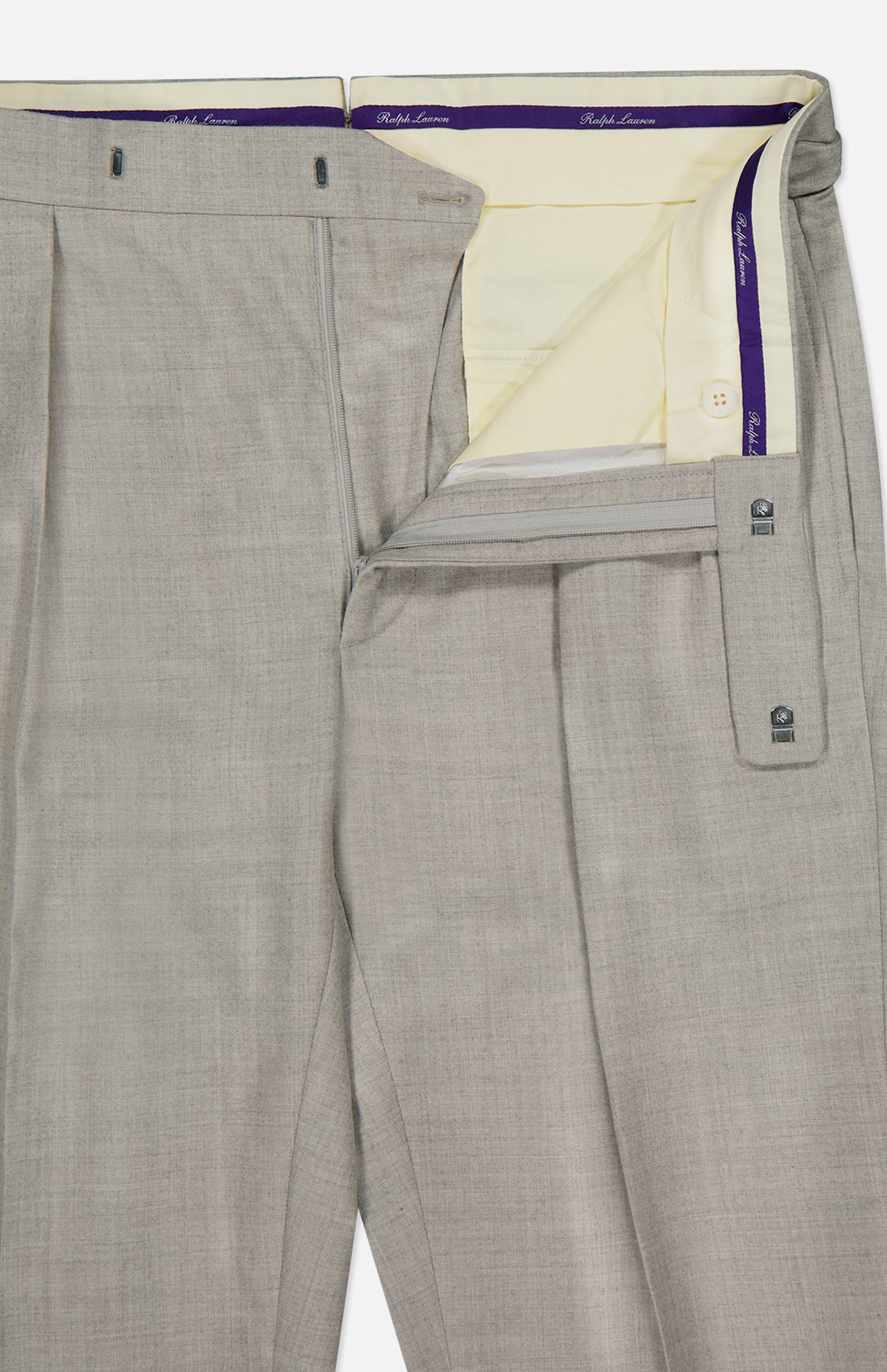 The Wool Flannel Pleated Trouser by RALPH LAUREN PURPLE LABEL is hand-tailored in Italy from light gray wool flannel. Shown with the waistband and fly open, these trousers reveal a cream-colored interior lining and a signature purple label. Finished with pleats, button closure, and belt loops.