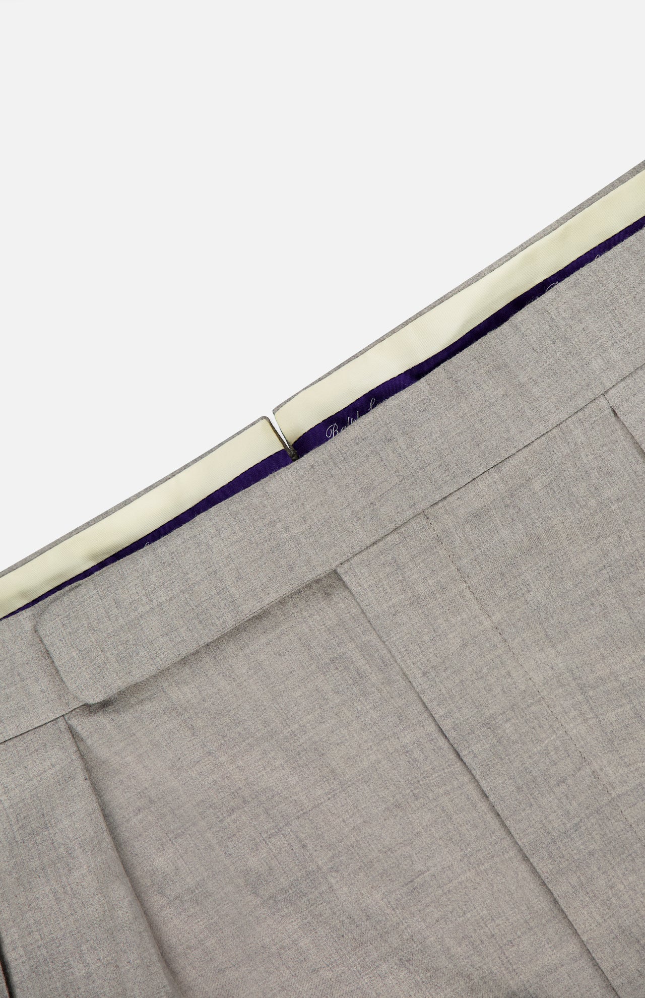 Close-up of the waistband and upper section of the RALPH LAUREN PURPLE LABEL Wool Flannel Pleated Trouser in light gray, highlighting the hook-and-bar closure and inner lining with a purple accent.