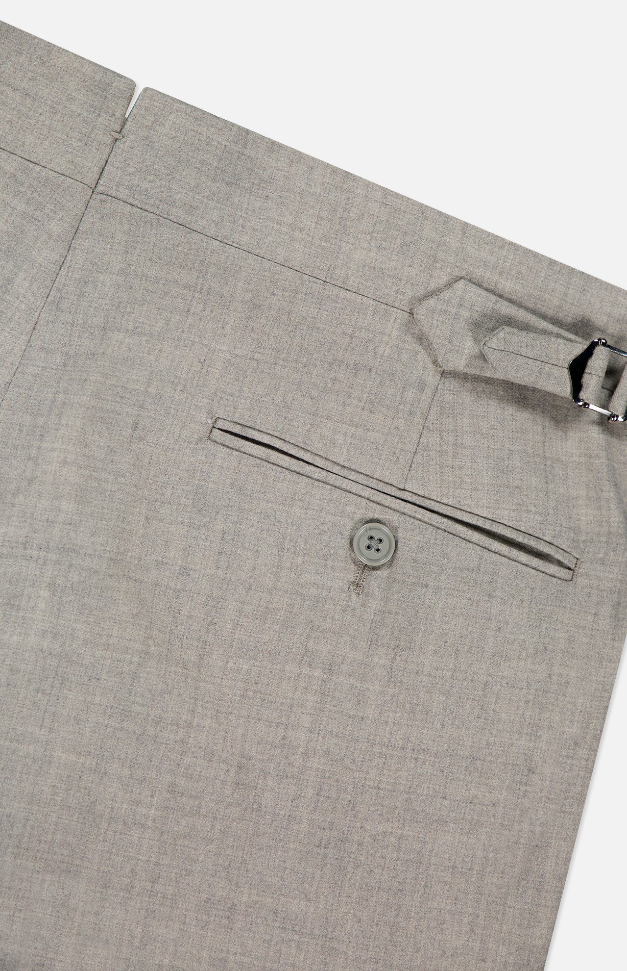 Close-up view of the RALPH LAUREN PURPLE LABEL Wool Flannel Pleated Trouser in light gray, featuring a back pocket with a button and a side adjuster with a metal buckle at the waistband; hand-tailored in Italy and shown against a plain white background.