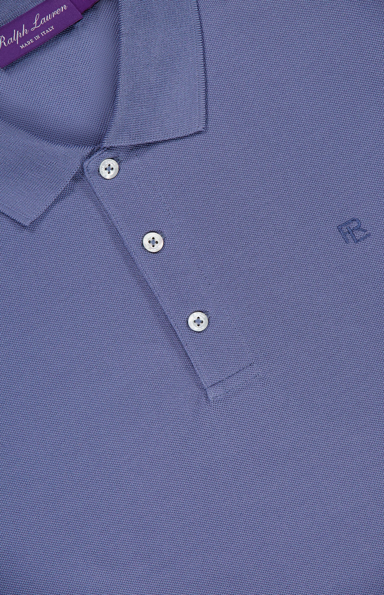 Close-up of a light purple RALPH LAUREN PURPLE LABEL Pique Short Sleeve Polo Shirt, featuring a collar, three white buttons, and a subtle RL logo on the chest. The brand label appears at the neckline. Made in Italy.