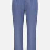 The Ralph Lauren Purple Label Silk Linen Dorset Flat Front Trouser features a light blue linen blend, elastic waistband with adjustable drawstring, straight legs, subtle front pleats, and a clean design without visible pockets.