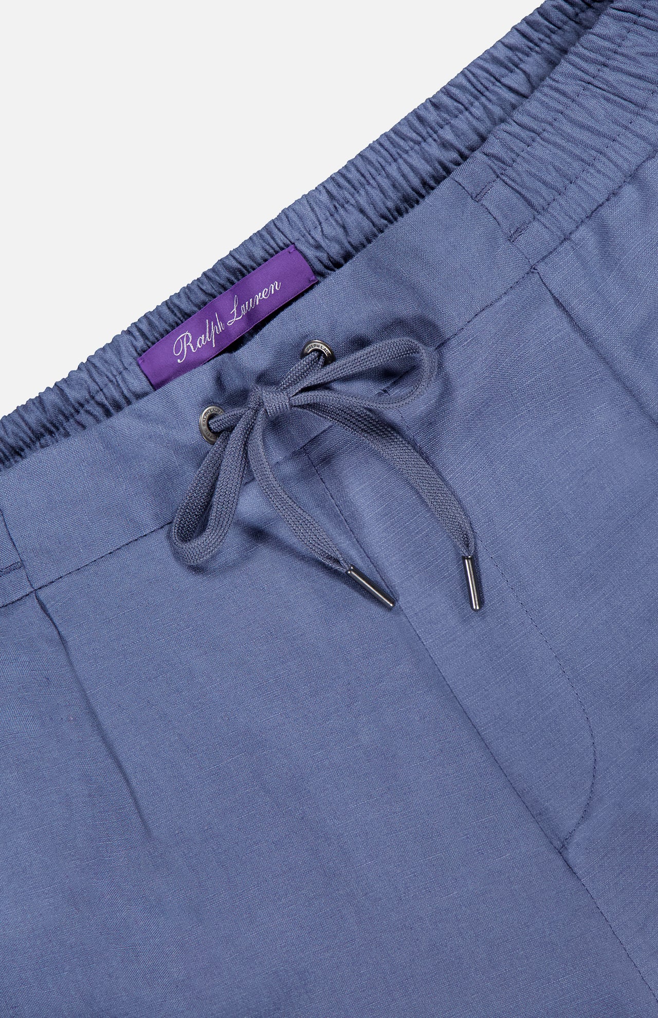 Close-up of light blue Silk Linen Dorset Flat Front Trouser featuring an elastic waistband and a visible purple Ralph Lauren Purple Label.