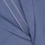 Close-up of the Ralph Lauren Purple Label Silk Linen Single Breasted Sportcoat in light blue, highlighting the lapel, chest pocket, single button, and inner lining with two beige stripes.