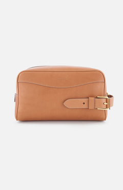 The Small Calfskin Saddle Pouch by RALPH LAUREN PURPLE LABEL is a tan leather travel organizer with white stitching, a front seam, and a gold-buckled strap on the right—ideal for men's grooming essentials and shown against a white background.