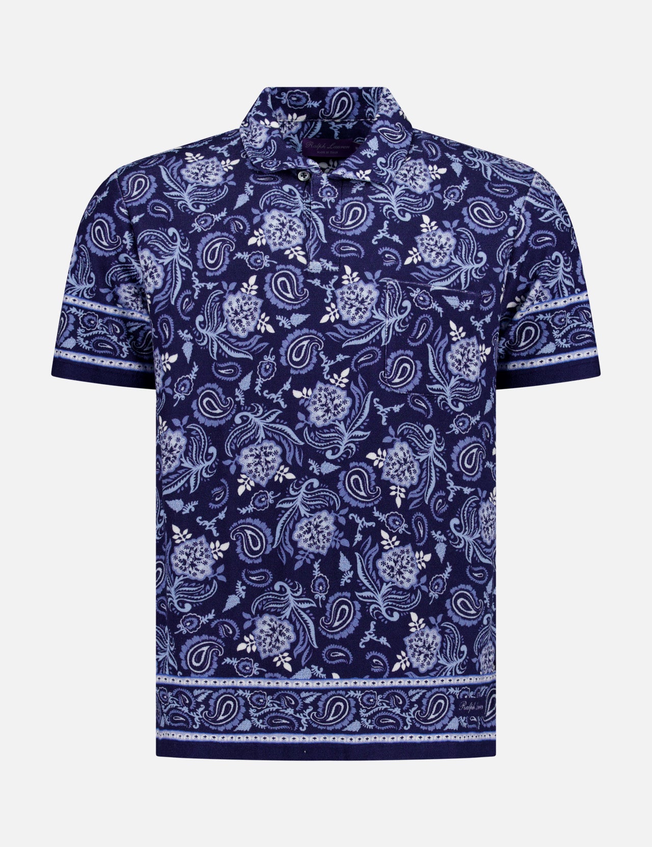 The Terry Short Sleeve Polo Shirt by RALPH LAUREN PURPLE LABEL features a navy cotton-blend fabric with an allover blue paisley and floral pattern, plus decorative borders on the sleeves and hem, shown against a plain white background.