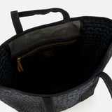 Open top view of the Cotton Banks Beach Bag by RALPH LAUREN RRL, hand braided in navy and black with indigo denim handles, showing its interior zippered pocket and small label. Features a textured dark blue pattern.