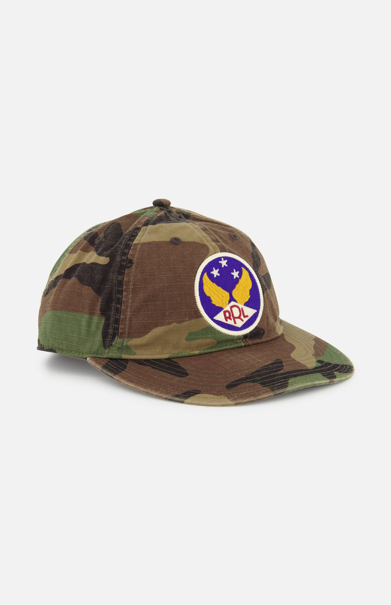 The RALPH LAUREN RRL Cotton Ripstop Printed Camo Ball Hat features a vintage look, round patch with yellow wings, blue background, three stars, red RRL letters, and an adjustable back strap for a perfect fit.