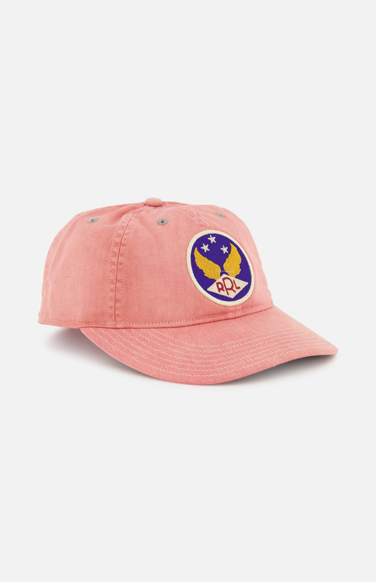 The RALPH LAUREN RRL Cotton Twill Faded Ball Hat is pink with a vintage feel, featuring a round patch of a yellow eagle, three white stars, and "PPL" lettering on blue.