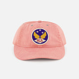 The Cotton Twill Faded Ball Hat by RALPH LAUREN RRL features soft pink cotton twill, a curved brim, and an embroidered patch with two yellow eagles, a star, and “RRL” on a blue and white circular background for vintage style.