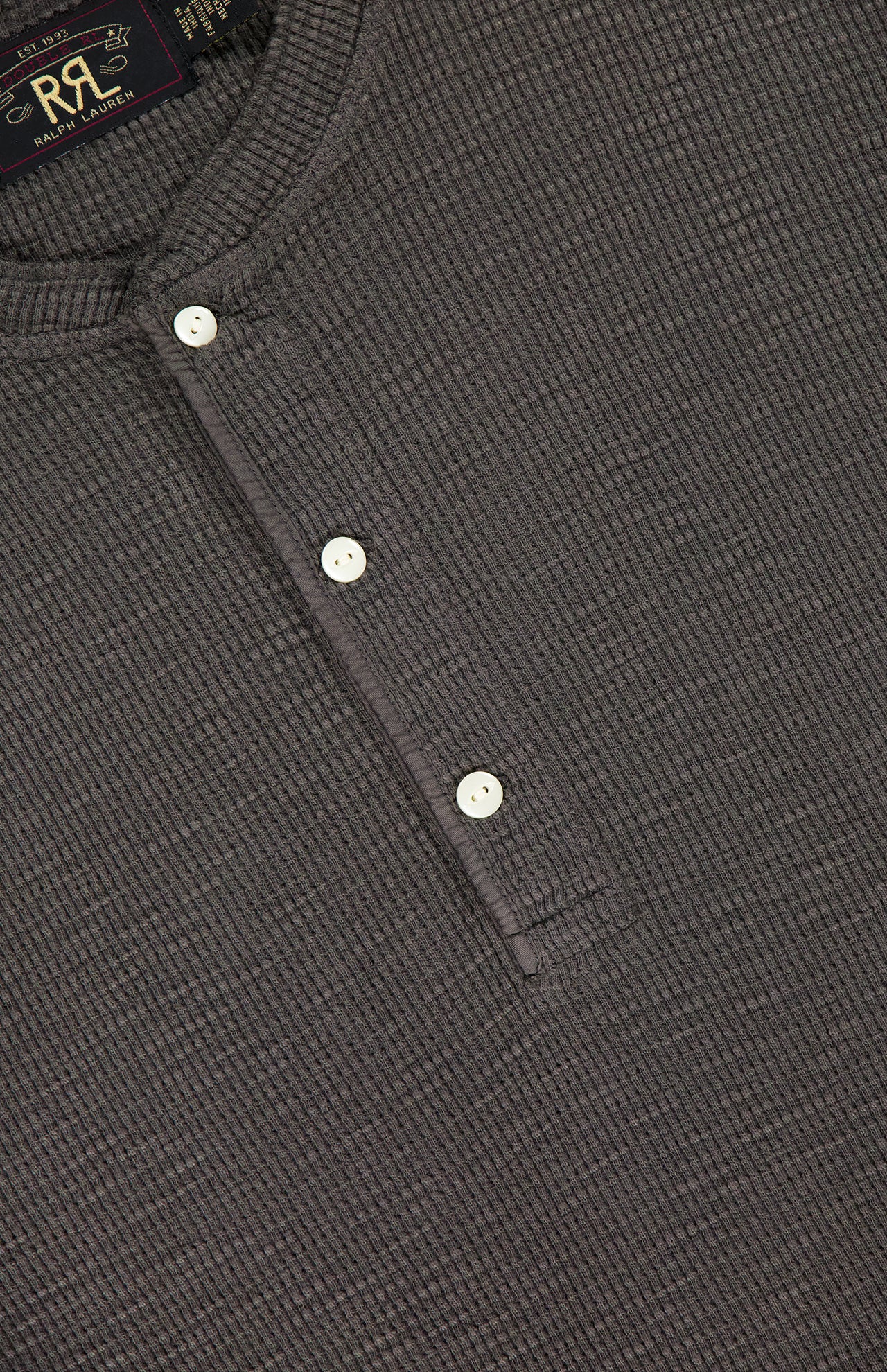 A close-up of the RALPH LAUREN RRL Cotton Waffle Knit Short Sleeve Henley Shirt, featuring a textured gray fabric, partial three-button placket, and subtle collar details for a stylish take on a classic casual staple.