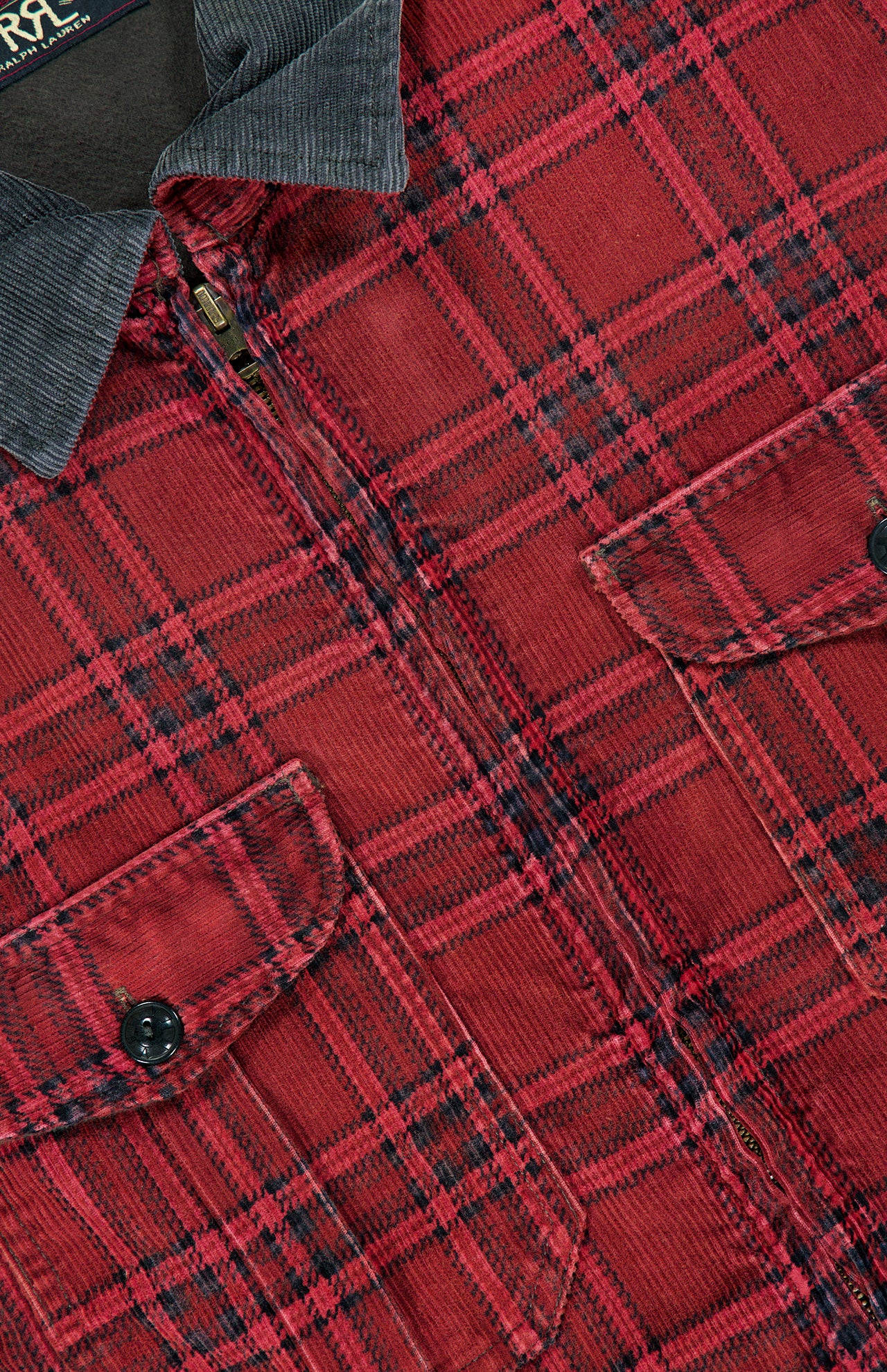 Close-up of the RALPH LAUREN RRL Cotton Zipped Corduroy Collared Overshirt in a red plaid pattern, featuring black buttons, two chest pockets, and a dark gray corduroy collar. This overshirt combines classic checkered styling with utility-inspired details for a versatile look.