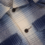 Close-up of the Ruddic Wool Blend Sport Shirt by RALPH LAUREN RRL, featuring a blue shadow-plaid pattern, black buttons, textured woven fabric, and a flap pocket on the left side—perfect as a classic vintage overshirt.