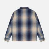 The RALPH LAUREN RRL Ruddic Wool Blend Sport Shirt is a vintage-inspired overshirt, showcased from the back against a plain white background. Featuring shadow-plaid in blue, white, and beige tones, this long-sleeve shirt boasts a classic collar and buttoned cuffs for timeless style.