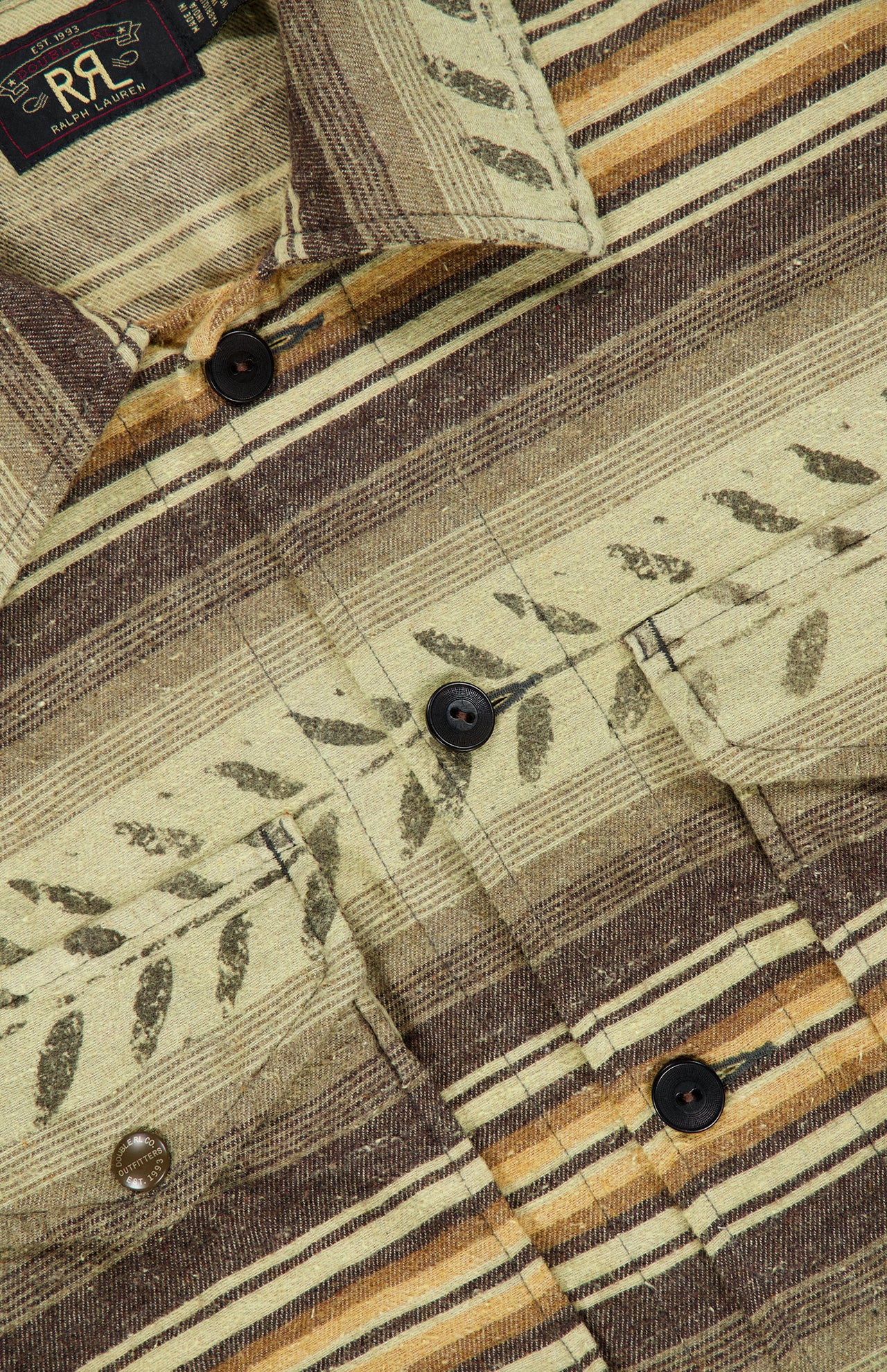 A close-up of the Sportman Cotton Sport Shirt by RALPH LAUREN RRL, featuring earthy-toned striped brushed cotton twill, leaf-like patterns, dark buttons, and a visible pocket.