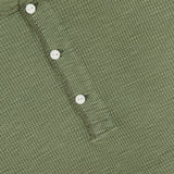 Close-up of the RALPH LAUREN RRL Waffle Knit Long Sleeve Henley Shirt in textured green waffle-knit cotton, featuring four white vintage-inspired buttons and a visible label at the neckline.