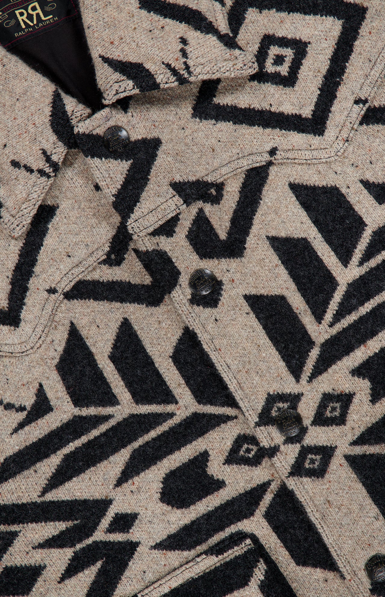 Close-up of a tan birdseye-jacquard Ralph Lauren RRL Western Ralston Wool Jacket featuring a black geometric and botanical pattern, metal button closures, and a pointed collar.