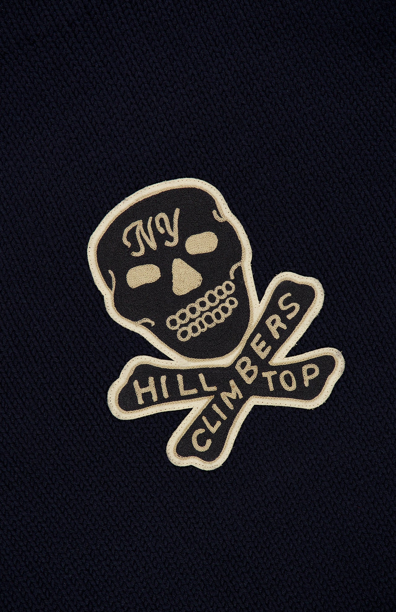 RALPH LAUREN RRL Wool Long Sleeve Crewneck Sweater in navy, featuring an embroidered skull and crossbones patch with NY on the forehead and HILL CLIMBERS on the crossbones.