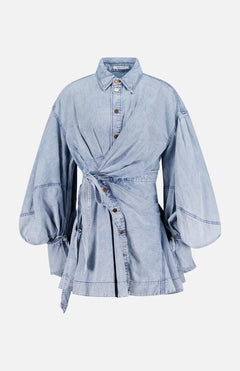 The Rebellion Denim Wrap Mini Dress by ZIMMERMANN features light blue denim, balloon sleeves, a button-down front, pointed collar, self-tie belt wrap silhouette, and a subtly flared hem with visible seam accents.