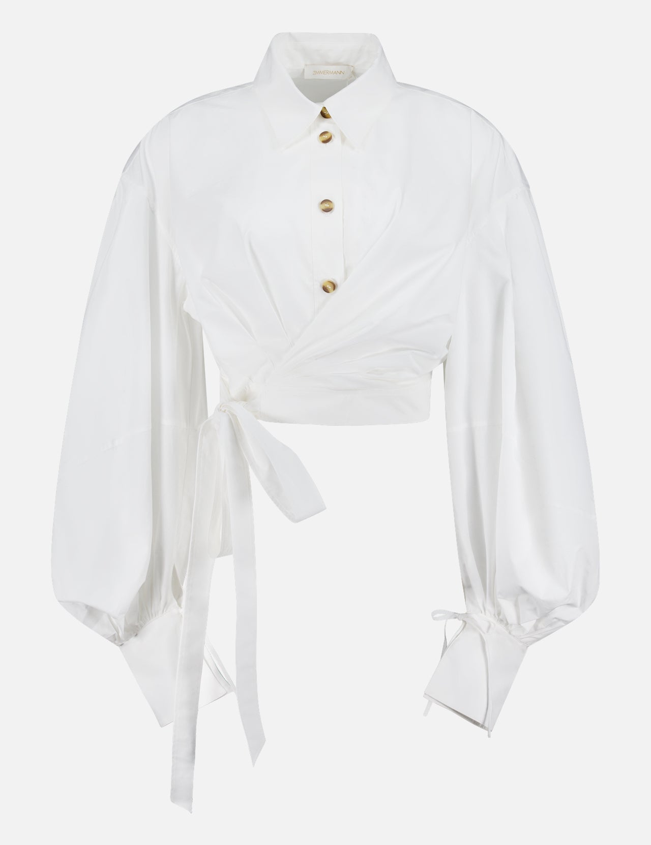 The Rebellion Poplin Wrap Blouse by ZIMMERMANN is an ivory cotton blouse with puffy sleeves, gold buttons, a dramatic wrap waist belt, and cuff ties. Cropped at the waist, it's shown on a plain white background.