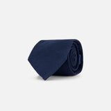 The Duvall Grenadine Unlined Tie by ROBERT TALBOTT in navy blue silk is neatly rolled and displayed on a plain light gray background.