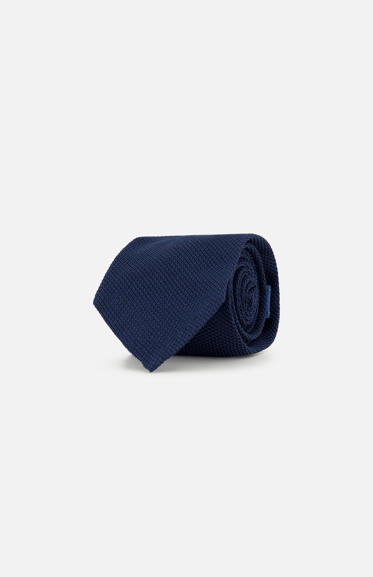 The Duvall Grenadine Unlined Tie by ROBERT TALBOTT in navy blue silk is neatly rolled and displayed on a plain light gray background.