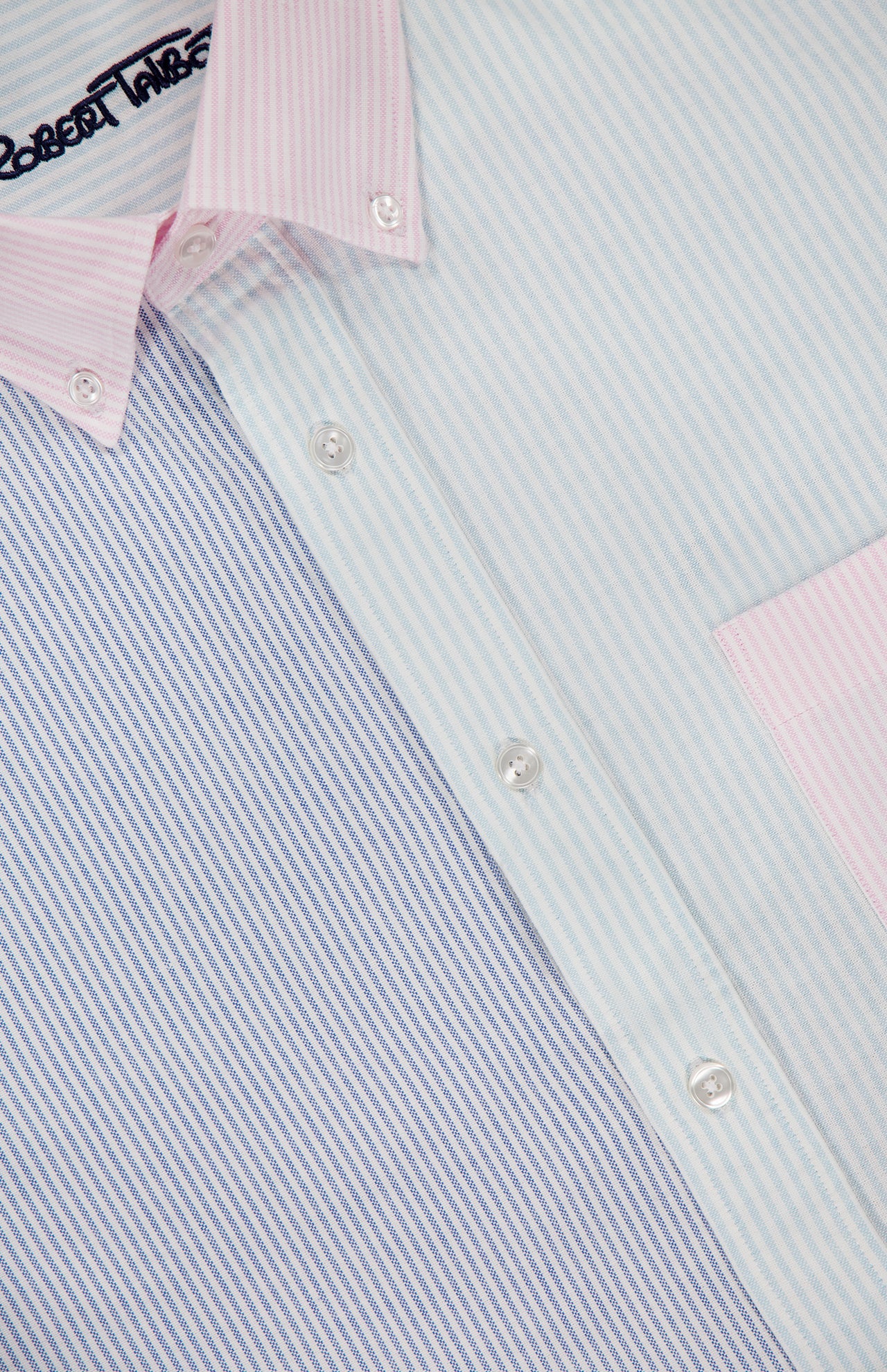 Close-up of the ROBERT TALBOTT Harrison Fun Stripe Oxford Dress Shirt, a cotton button-down with vertical blue, green, and pink pastel stripes, pink collar and pocket, white buttons, and a partially visible label near the collar.