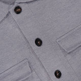Close-up of the Landon Sweater Jacket, a light gray button-up by ROBERT TALBOTT featuring two chest pockets and dark buttons. The inside collar label displays ROBERT TALBOTT TAILORED FIT. Designed in a tailored fit, this piece combines the polished look of a classic shirt with the versatility of a hybrid sweater-jacket, making it perfect for layering throughout any season.