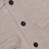 Close-up of the ROBERT TALBOTT Landon Sweater Jacket in beige, showcasing its tailored fit, textured fabric, black buttons, two chest pockets, and a partially visible blue tag at the collar.