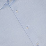 The Reynolds Contemporary Cotton Linen Dress Shirt by ROBERT TALBOTT is light blue with a subtle texture, white buttons, a collar, and a visible label—perfect for business casual wear.