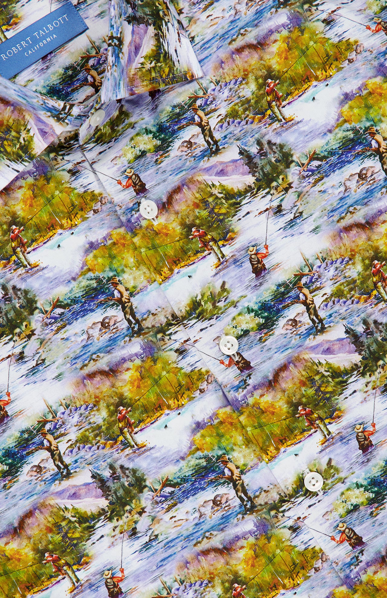 Close-up of a colorful Italian cotton dress shirt fabric from ROBERT TALBOTT, featuring a vintage print of a fishing scene with people, trees, and mountains. The Reynolds Fishing Scene Dress Shirt has white buttons and a visible blue Robert Talbott label near the collar.