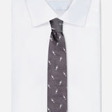 A neatly folded white dress shirt with the ROBERT TALBOTT Robert Champagne Glass Tie—a dark grey silk tie featuring a repeating champagne glass pattern.