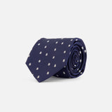 A rolled-up ROBERT TALBOTT Robert Dollar Signs Tie in navy blue silk, adorned with a pattern of small white dollar signs, placed on a plain white background.