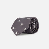 The Robert Pin-Up Silhouette Tie by ROBERT TALBOTT is rolled up neatly on a plain white background, featuring a dark grey silk fabric adorned with small white running person silhouettes.