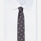 A neatly folded white dress shirt paired with a ROBERT TALBOTT Robert Pin-Up Silhouette Tie—a dark grey silk necktie adorned with a repeating small white pattern—displayed on a plain background.