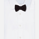 A luxurious ROBERT TALBOTT Ryan Silk Knit Pre-Tied Bow Tie in black, handmade in Italy, is elegantly displayed on a neatly folded white dress shirt against a plain white background.