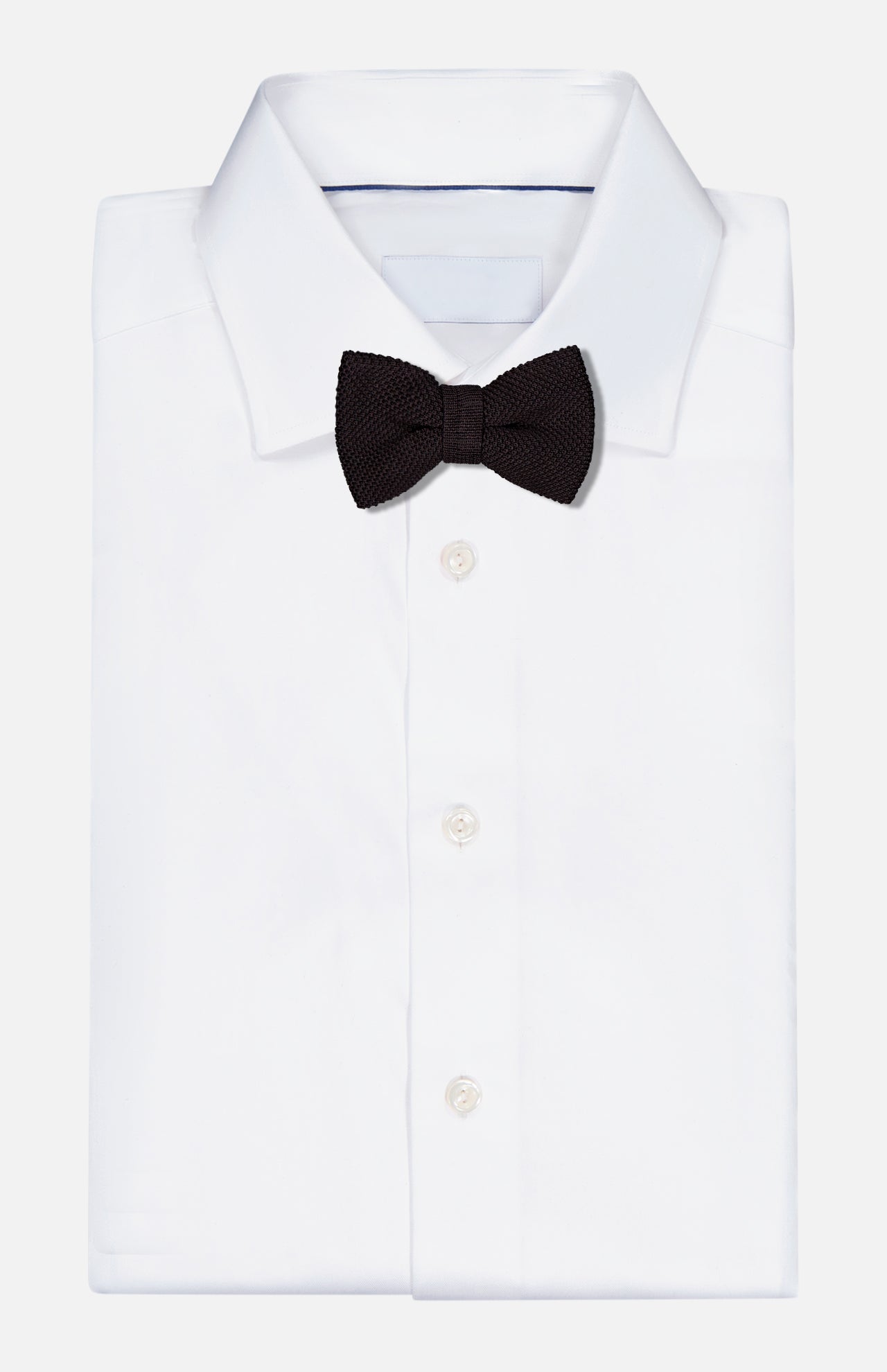 A luxurious ROBERT TALBOTT Ryan Silk Knit Pre-Tied Bow Tie in black, handmade in Italy, is elegantly displayed on a neatly folded white dress shirt against a plain white background.