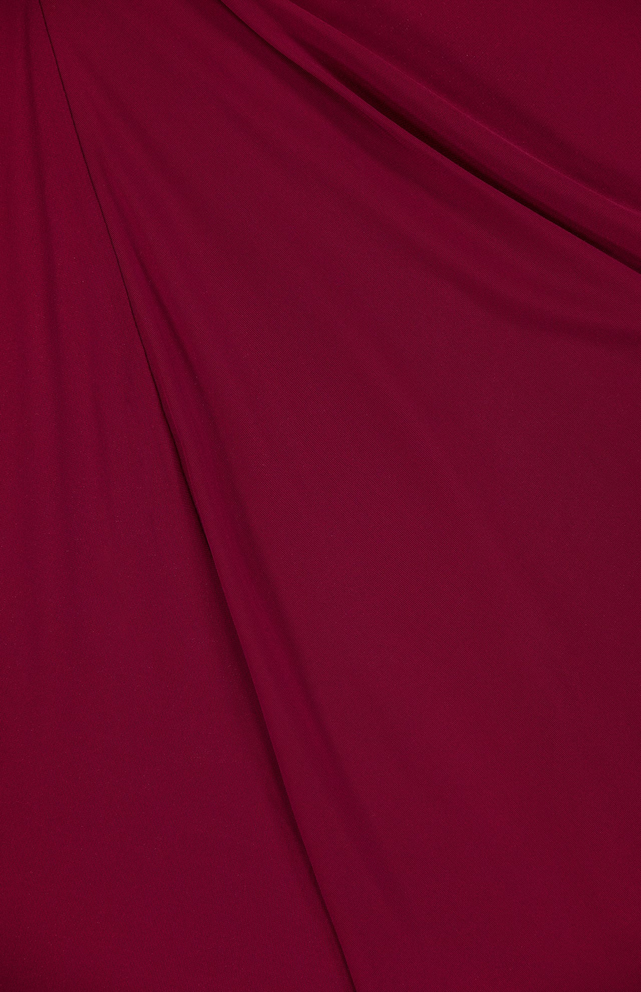 A close-up of deep red fabric with soft folds and drapes, echoing the elegant lines and shadows of the Anya Ruched Maxi Dress by RONNY KOBO.