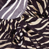 Close-up of the Aubrey Zebra Print Ruffle Top by RONNY KOBO, featuring black and white animal stripes, ruffled edges, and a tied bow detail.
