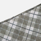 A close-up of the Azana Mesh Plaid Skirt by RONNY KOBO, showcasing its gray, green, and white checkered pattern diagonally on a white background—ideal for elevating your office style.