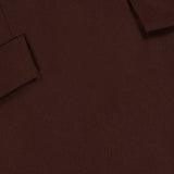Close-up of the Brette Pocket Mini Dress by RONNY KOBO in chocolate brown fabric, featuring two angled, rectangular flaps stitched at the top corners—details that hint at tailored, jacket-inspired design elements.