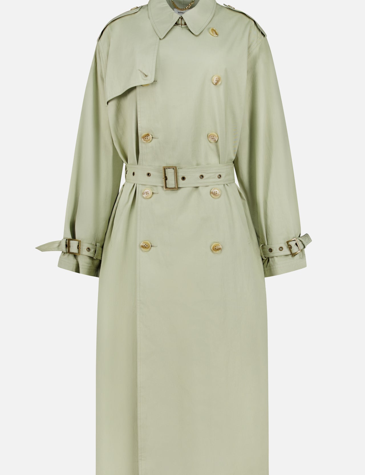 The Cohen Oversized Raincoat by RONNY KOBO is a light sage green, trench-inspired coat featuring a belted waist, double-breasted front with gold buttons, shoulder epaulets, and buckled cuff straps, shown on a plain white background.