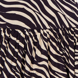 Close-up of the Feyre Animal Print Skirt by RONNY KOBO, featuring bold black and white zebra stripes. The image showcases the gathered design with a visible waistband at the top.