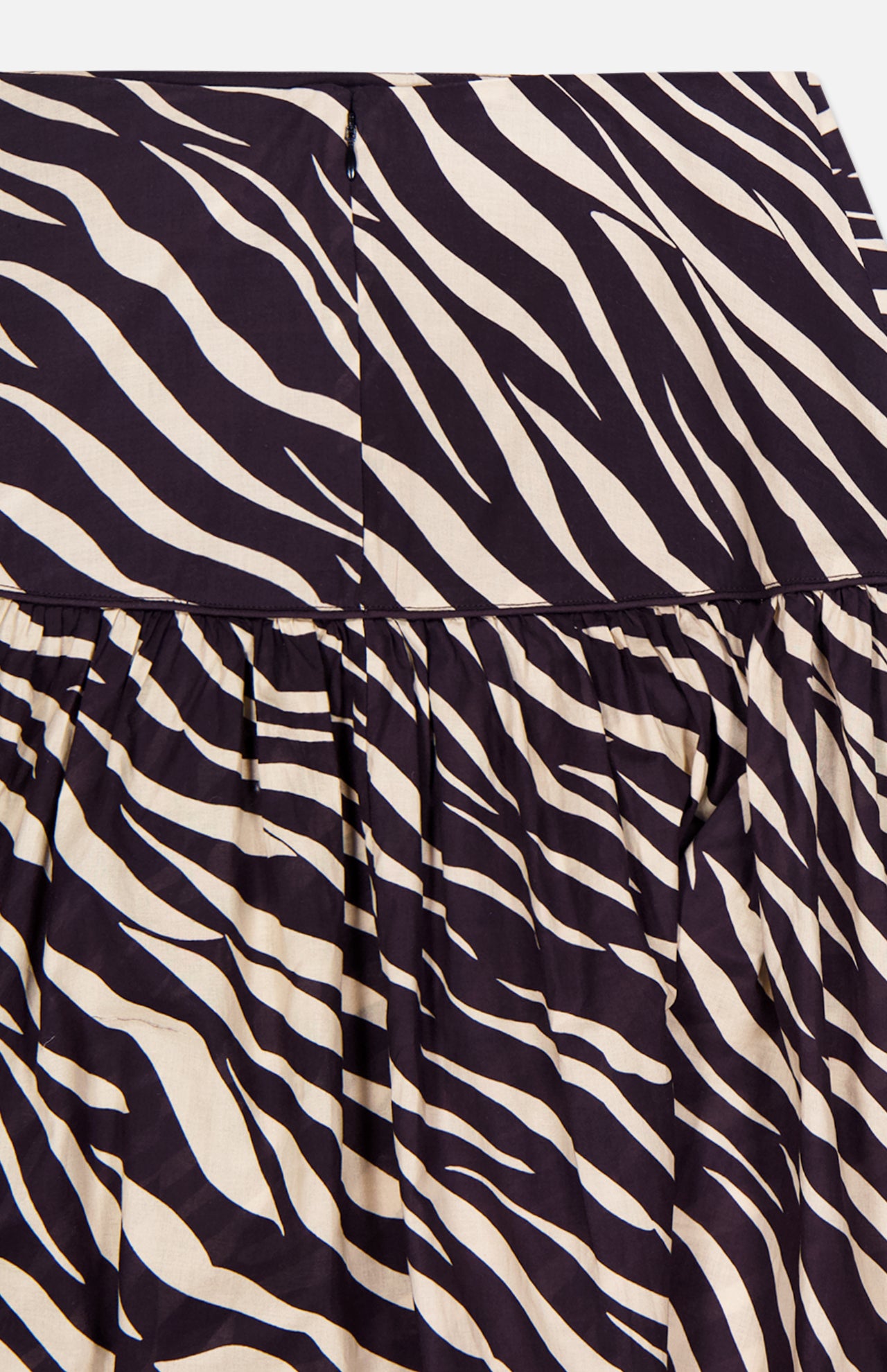 Close-up of the Feyre Animal Print Skirt by RONNY KOBO, showcasing bold black and cream zebra stripes with gathered pleats that highlight its striking animal print fabric.