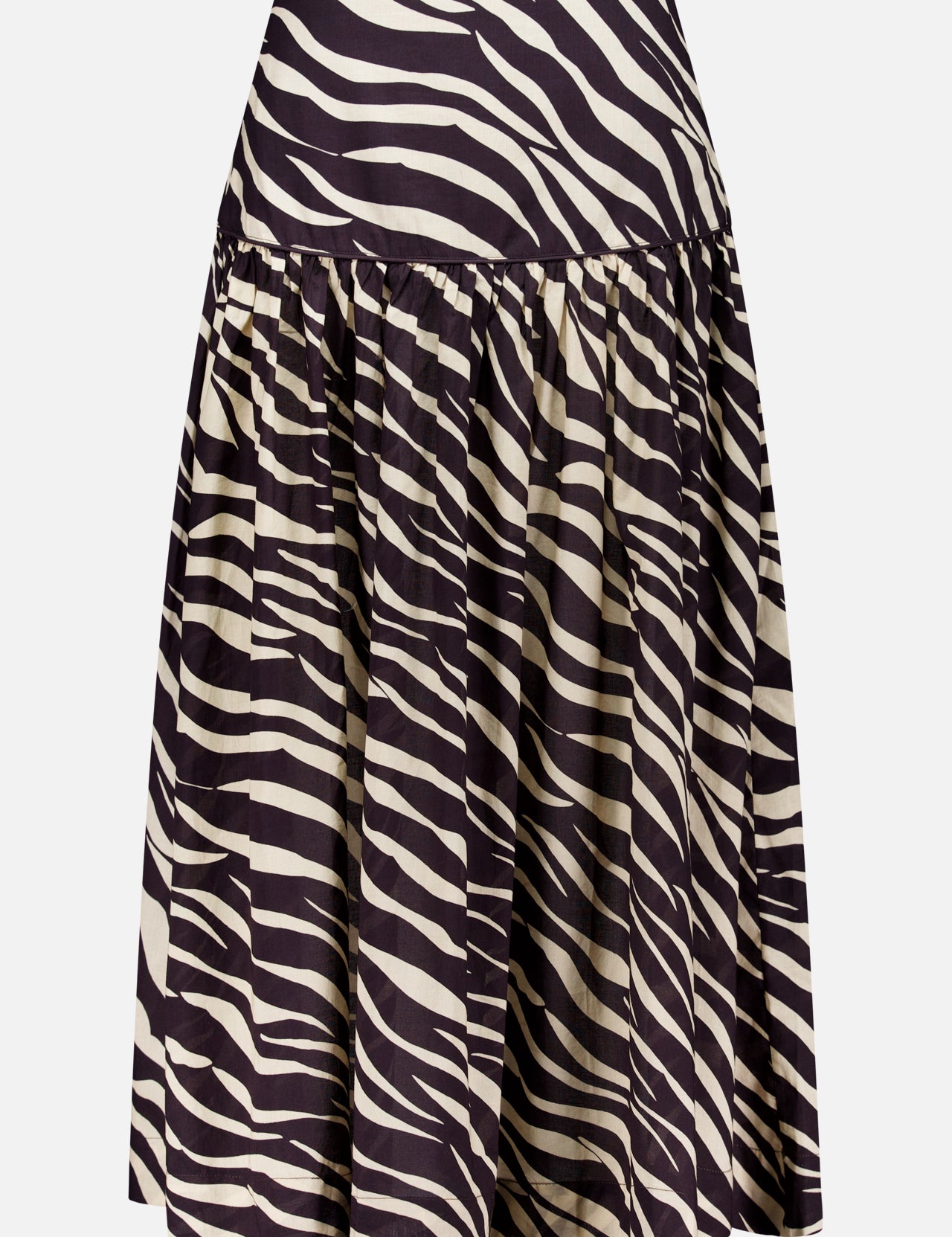 The Feyre Animal Print Skirt by RONNY KOBO is a knee-length, flared design with a high waist and bold black-and-white zebra print. It features gathered fabric at the waistband for a full, flowing silhouette and has a subtle sheen.