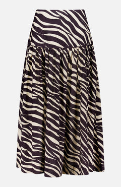 The Feyre Animal Print Skirt by RONNY KOBO is a knee-length, flared design with a high waist and bold black-and-white zebra print. It features gathered fabric at the waistband for a full, flowing silhouette and has a subtle sheen.