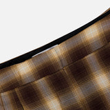 Close-up of the Hayes Plaid Straight Leg Pant by RONNY KOBO, showcasing its brown and yellow plaid pleated fabric, high-rise waist, and straight-leg silhouette against a plain light background.